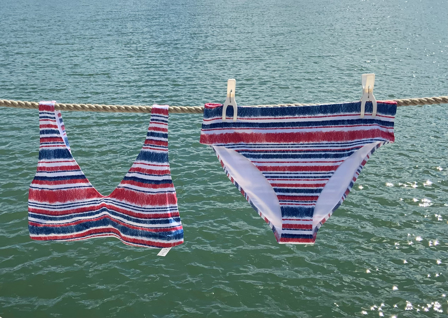 Marine bikini hanging against sea